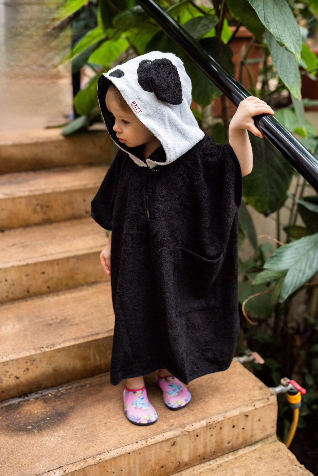 confident toddler in a bold panda poncho with hood and pockets for beach adventures