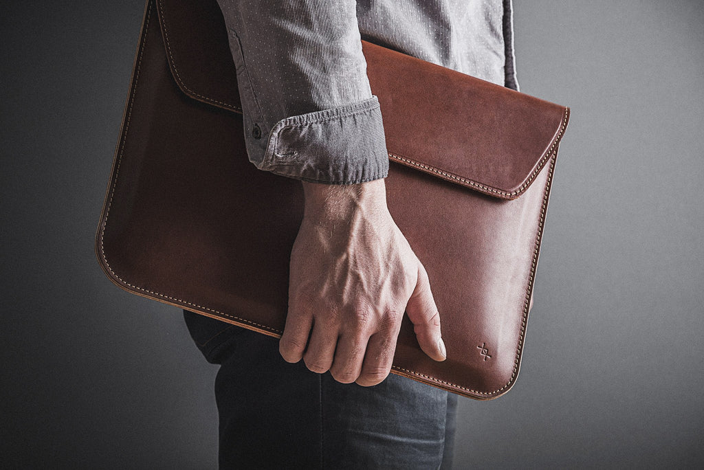 slim note sack open on a wooden desk revealing its soft interior and elegant leather stitching