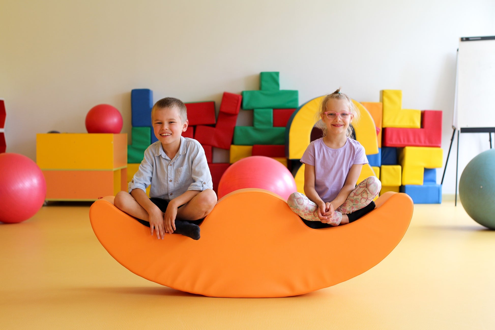 elegant orange double rocker for two children in a modern nursery setting