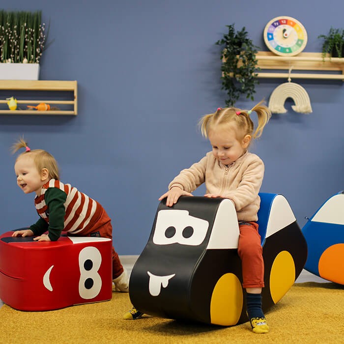 elegant red iglu soft play car for kids on a minimalist nursery floor