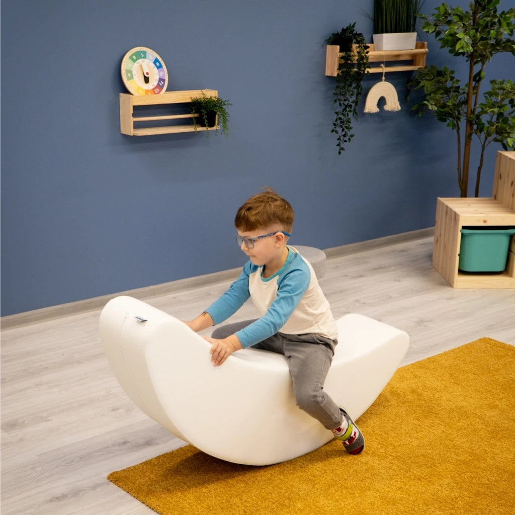 elegant white banana rocking toy for kids, promoting balance and creativity in a minimalist nursery