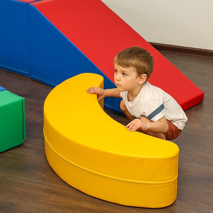 a child gently rocking on a soft yellow banana toy in a cozy nursery setting