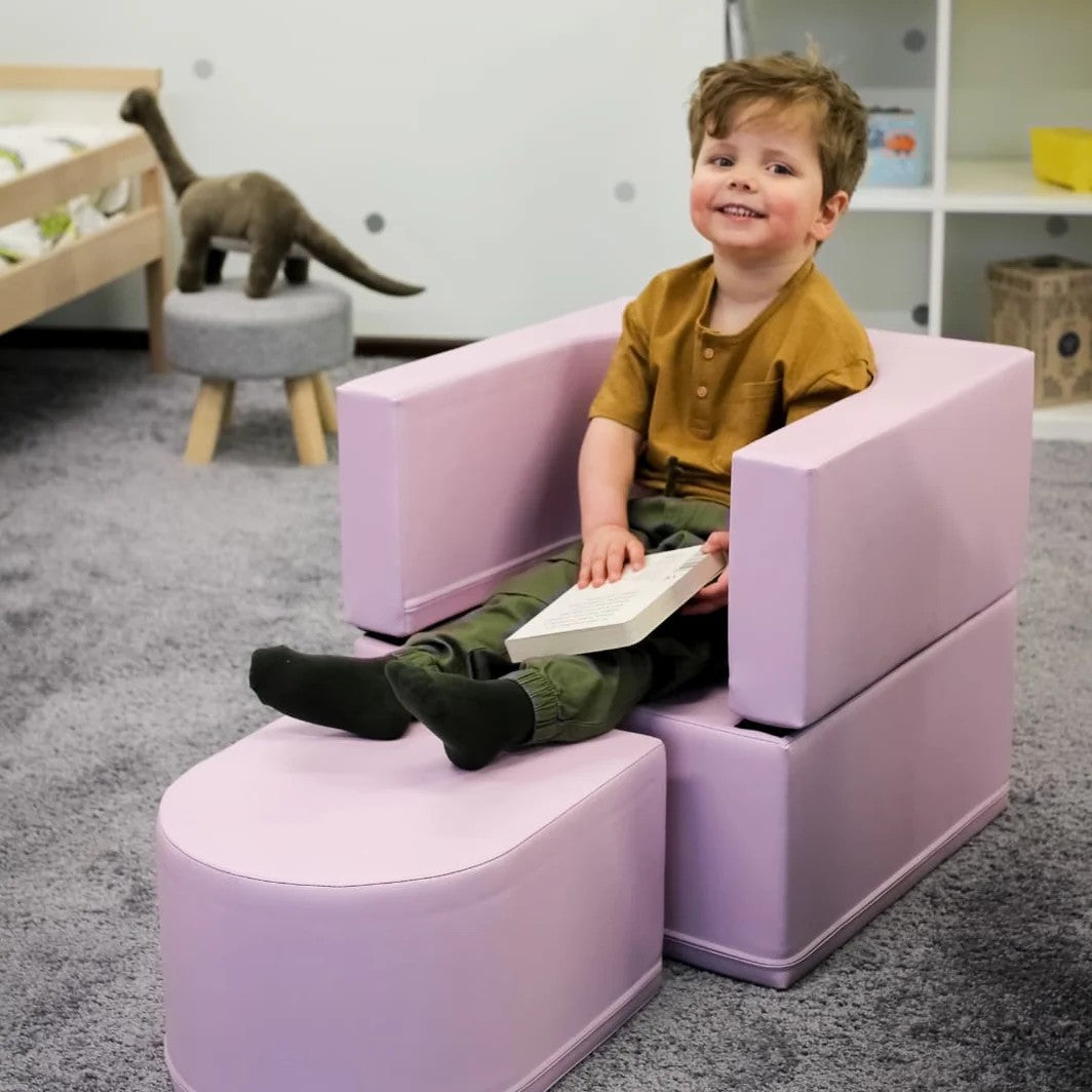 a soft pink kids sofa chair bathed in gentle morning light, looking cozy and huggable
