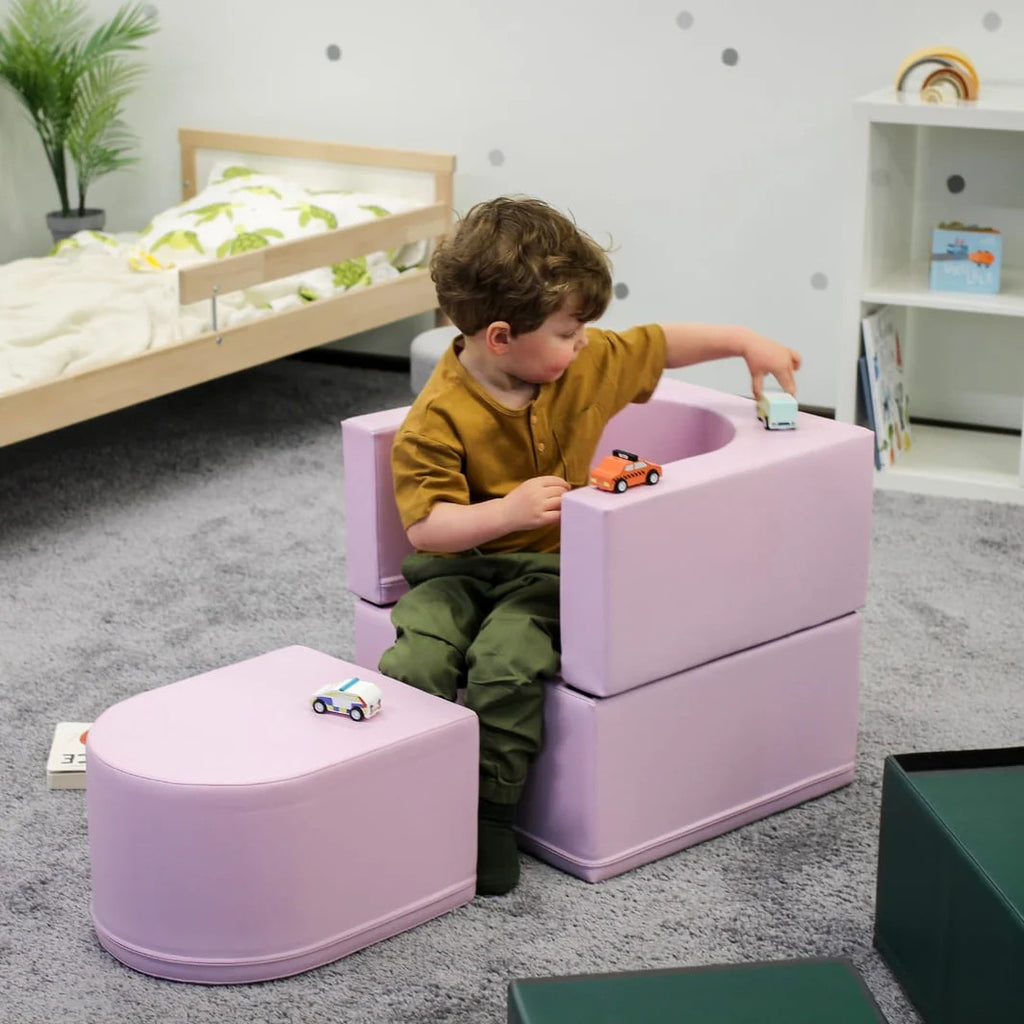 a pink snoozy sofa chair unfolded as a lounge mat for a child's quiet reading time