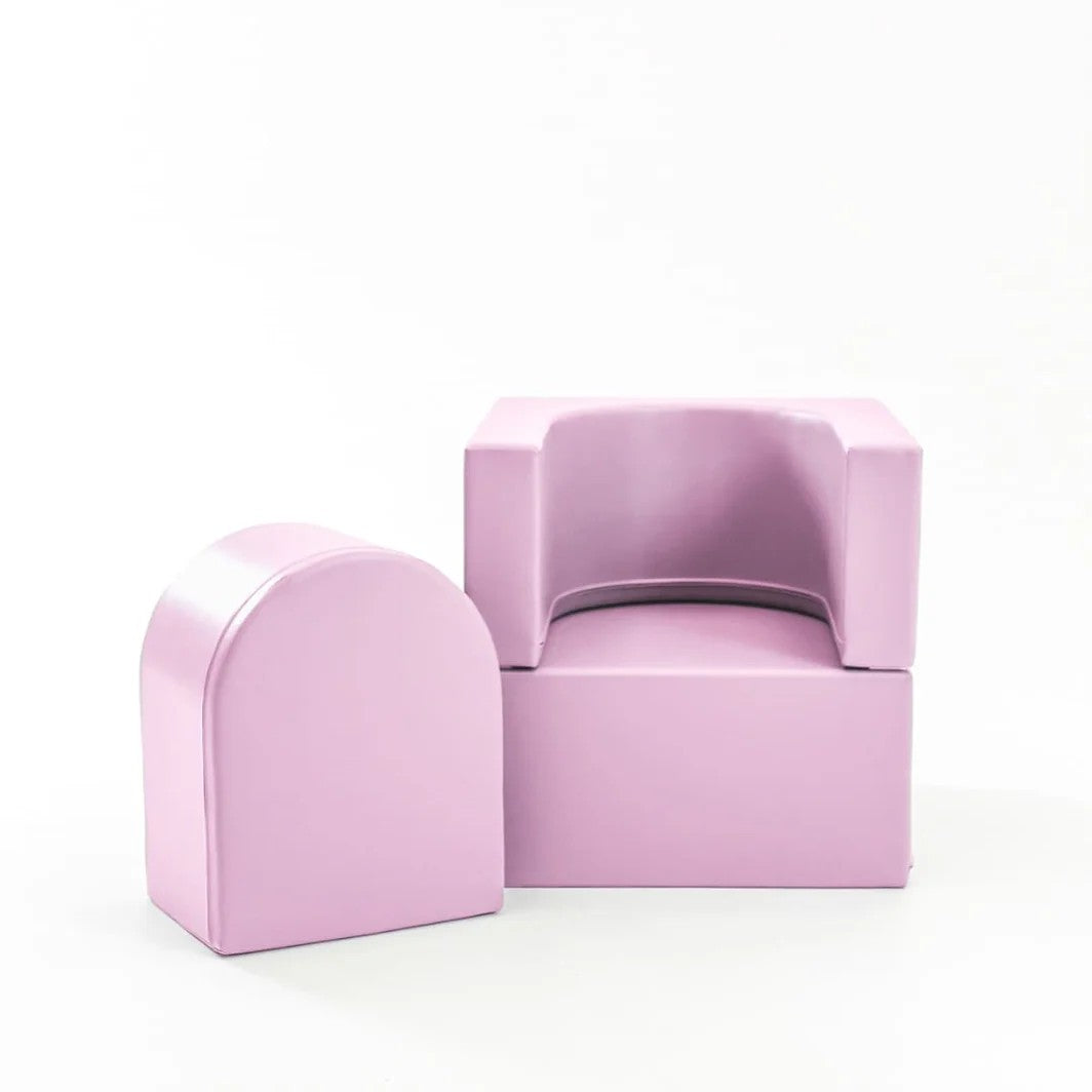 a child's plush pink snoozy sofa chair shown in a soft, elegant home setting