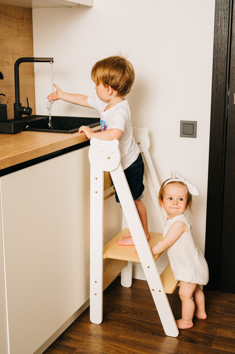 confident toddler reaching kitchen counter on a bold birch step stool