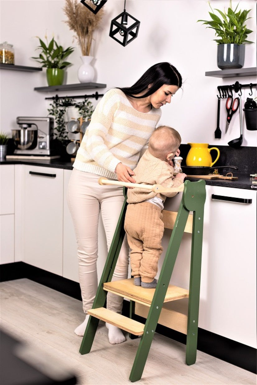 foldable baltic birch step stool leaning against a sunlit kitchen wall