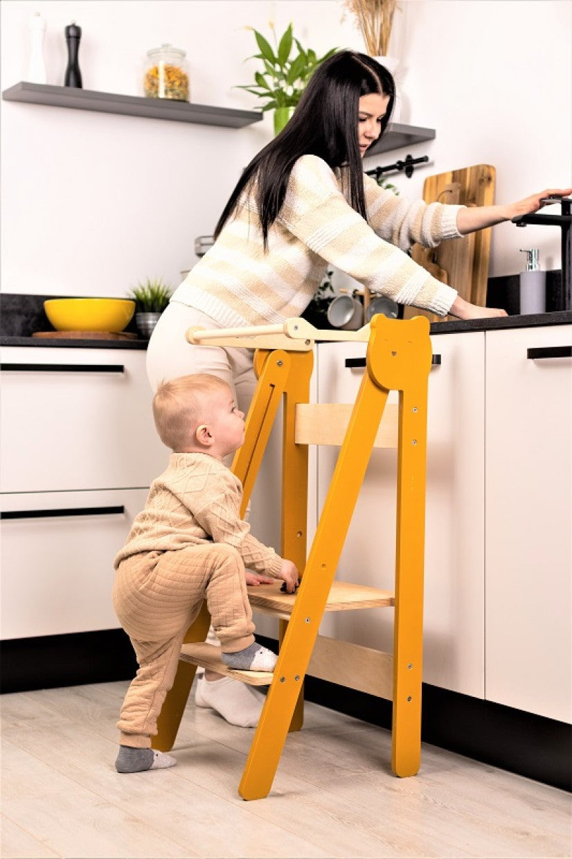 foldable baltic birch step stool for kids folded flat against a modern kitchen wall