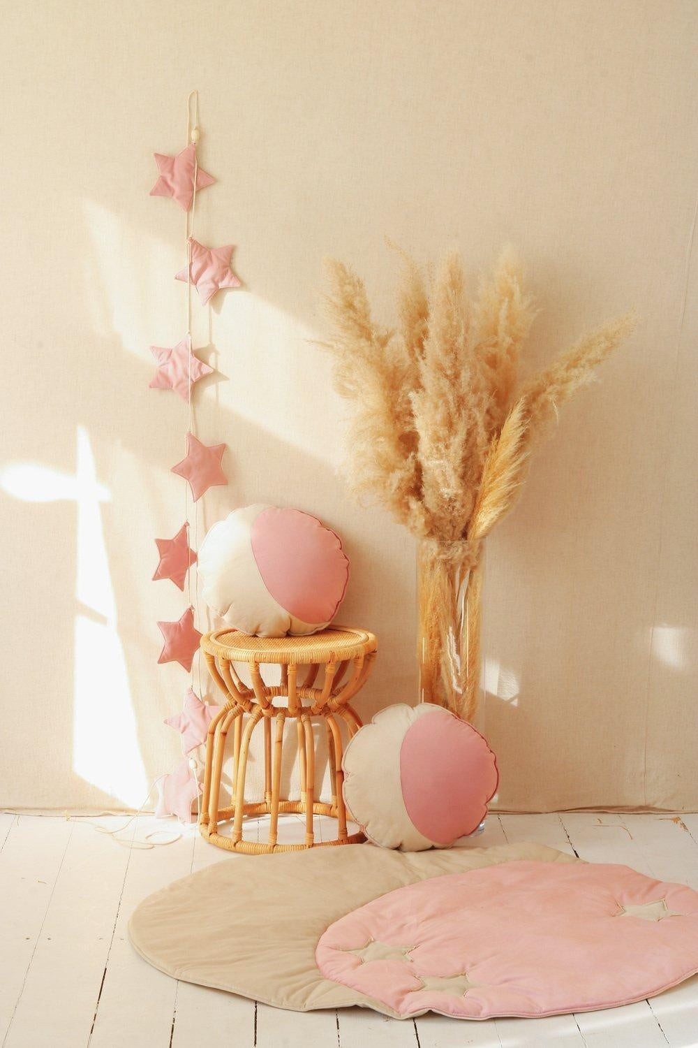 elegant soft pink velvet star garland with wooden beads hanging in a refined nursery