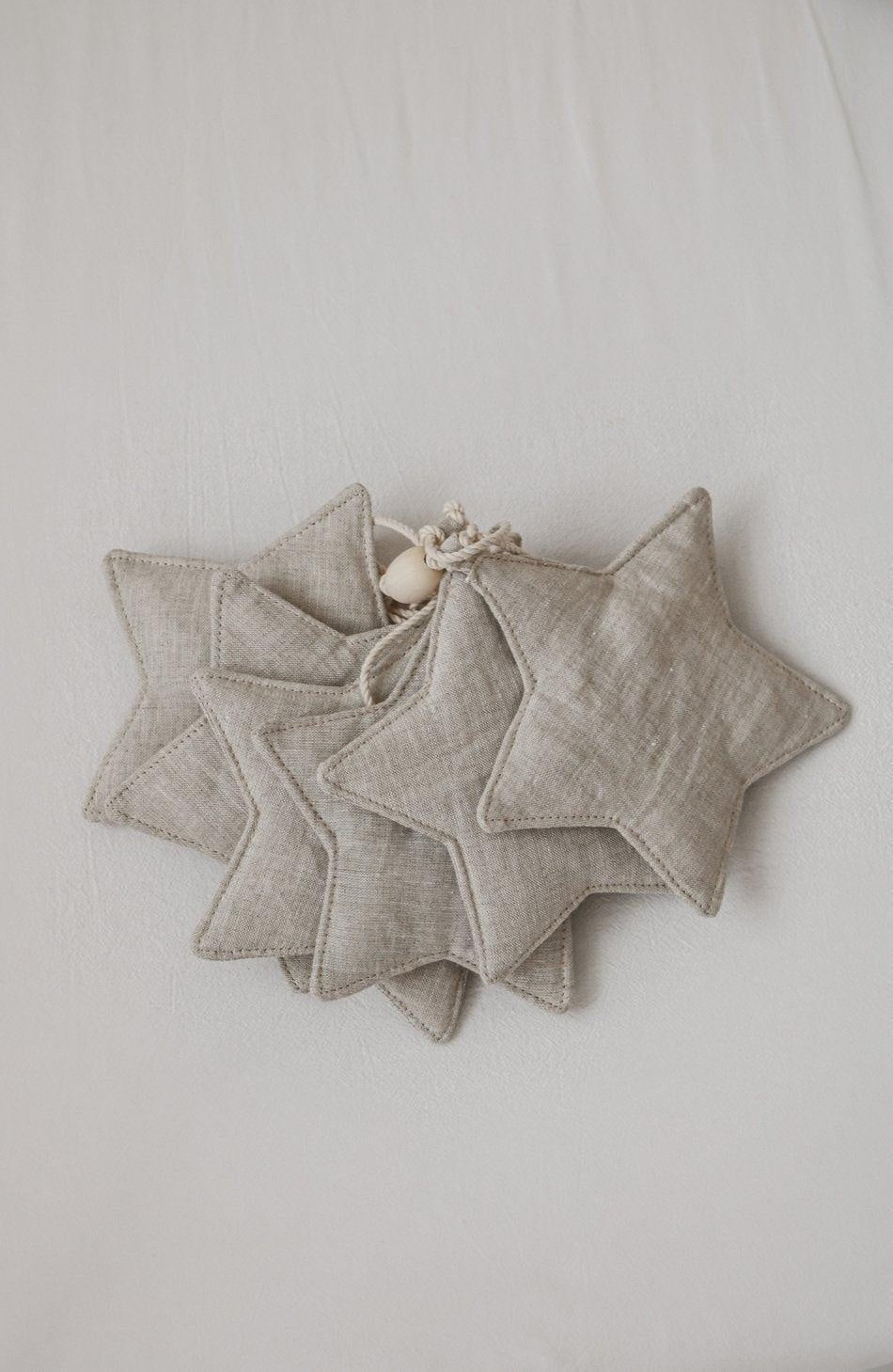 bold artisan-made sand star dust garland hanging against a dark nursery wall
