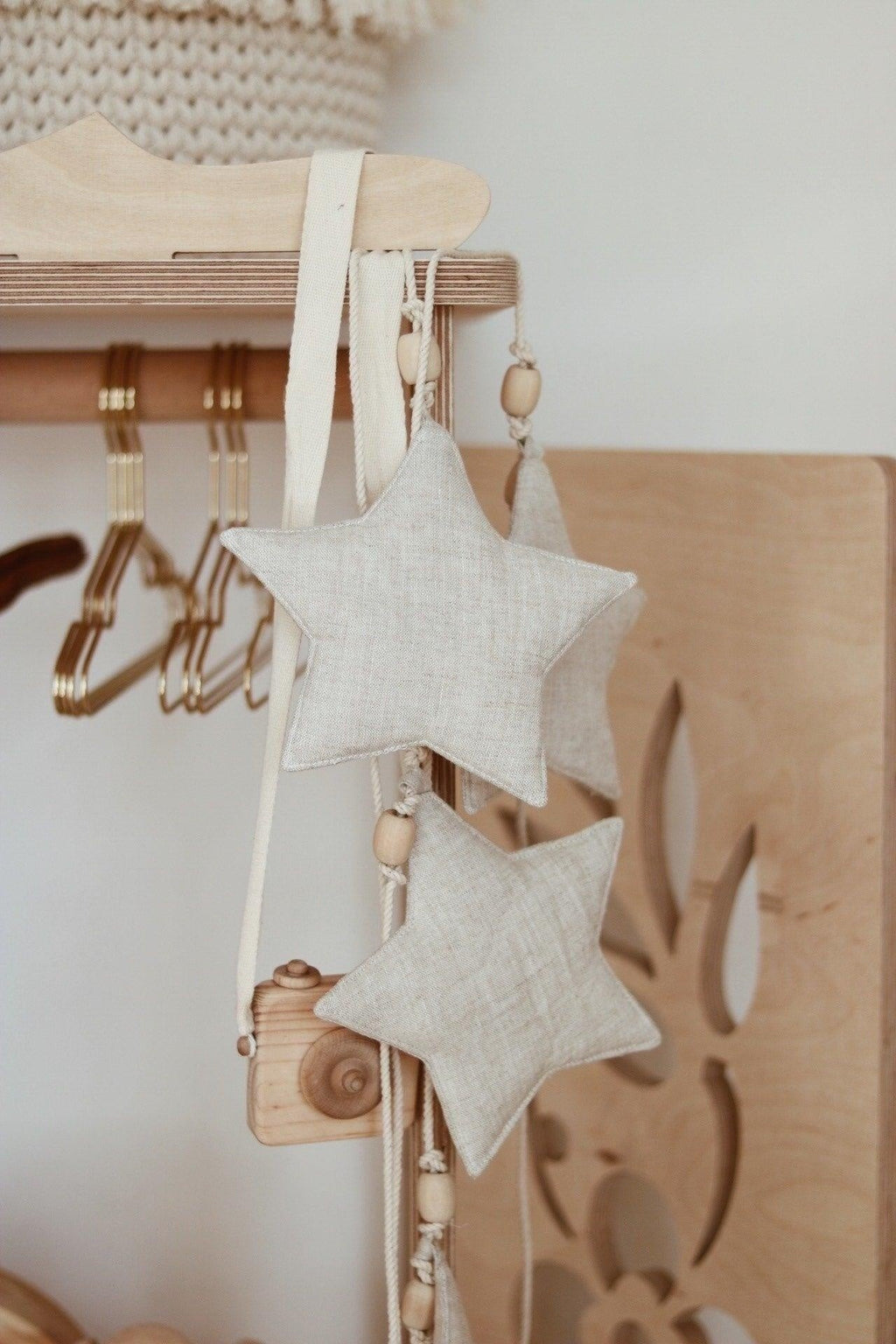 playful sand star dust garland with wooden beads hanging over a colorful play mat