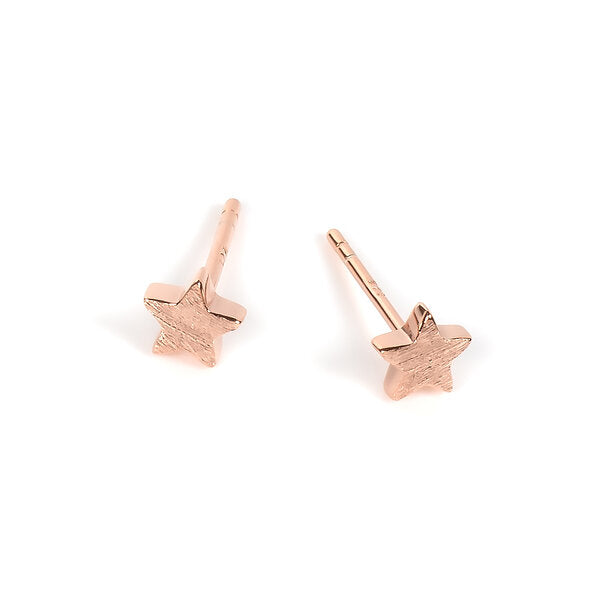 softly lit rose gold star earrings glowing against a gentle morning backdrop