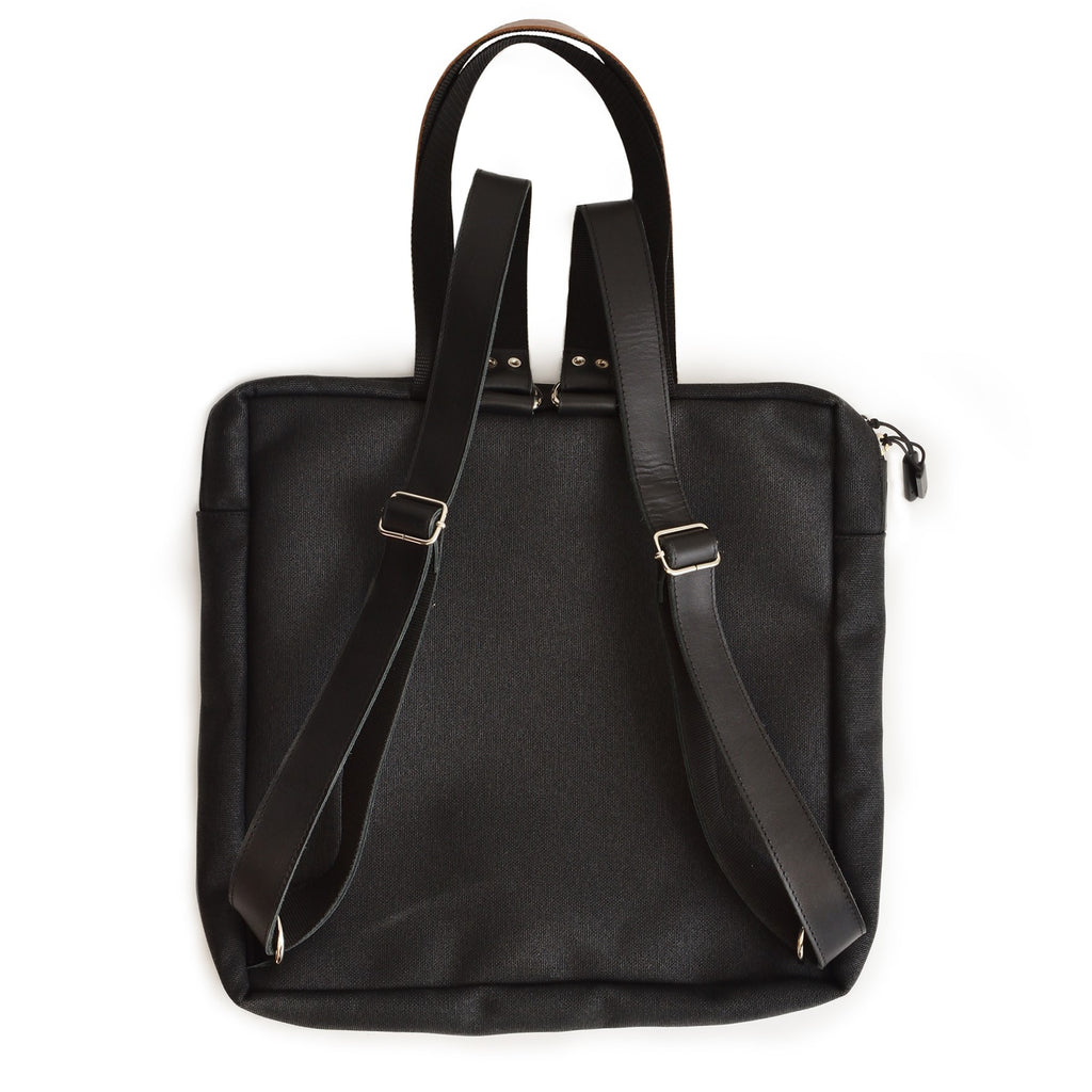 playful purple and black stockholm backpack with leather accents, shown in warm natural light