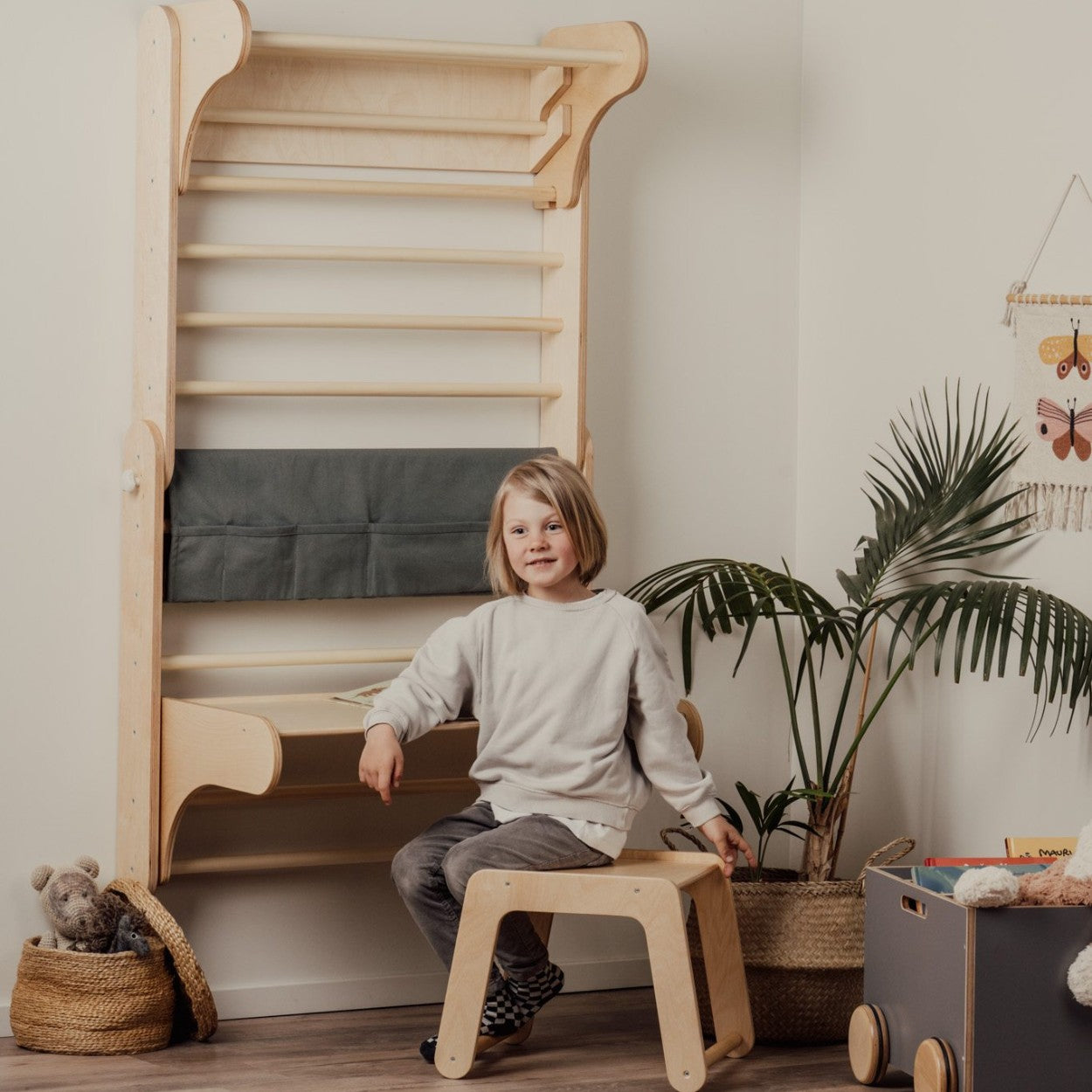 a child's hand reaching for the birch plywood climbing table set during imaginative play