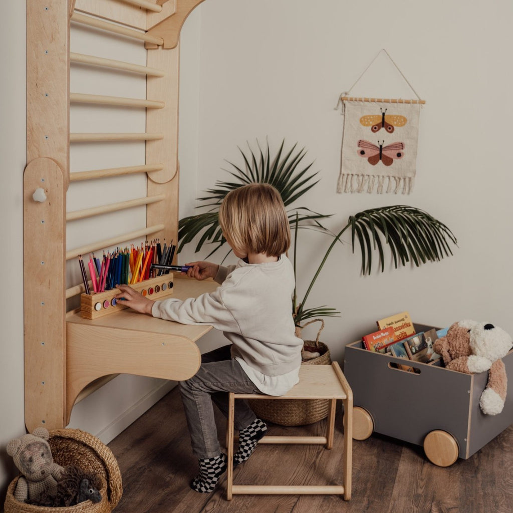 a child cozily perched on the birch plywood climbing chair in soft, warm light