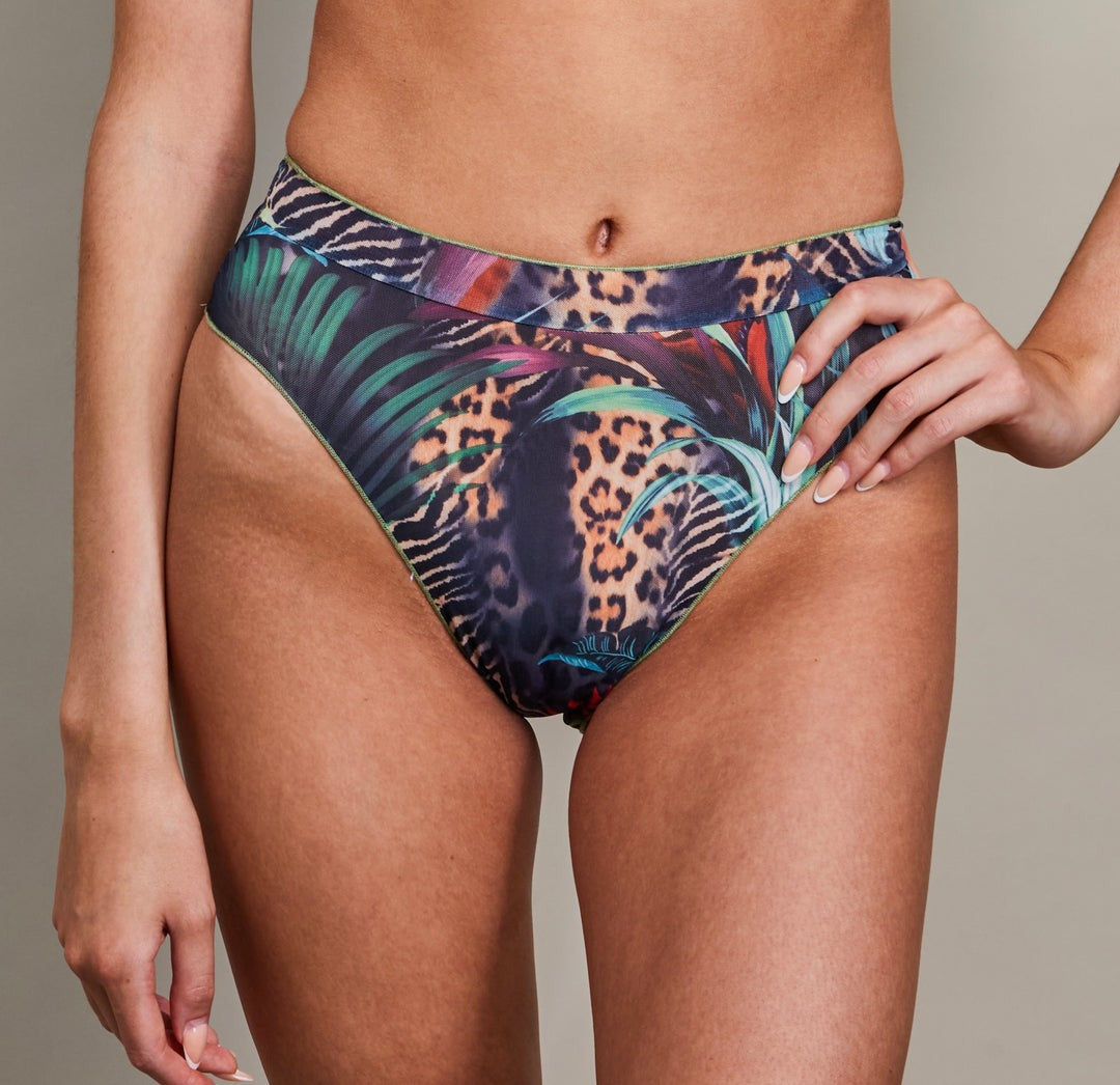 a playful seashell bikini top in golden hour light on a sandy beach