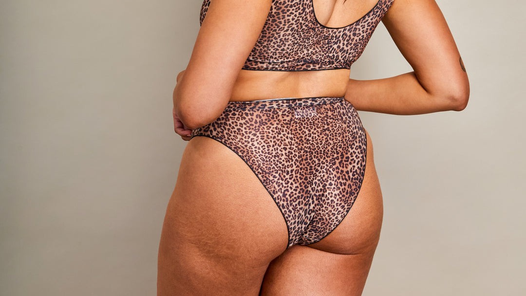 practical tan-through long sleeve bikini set on a beach towel, showcasing the high-waisted coverage and eco-friendly fabric