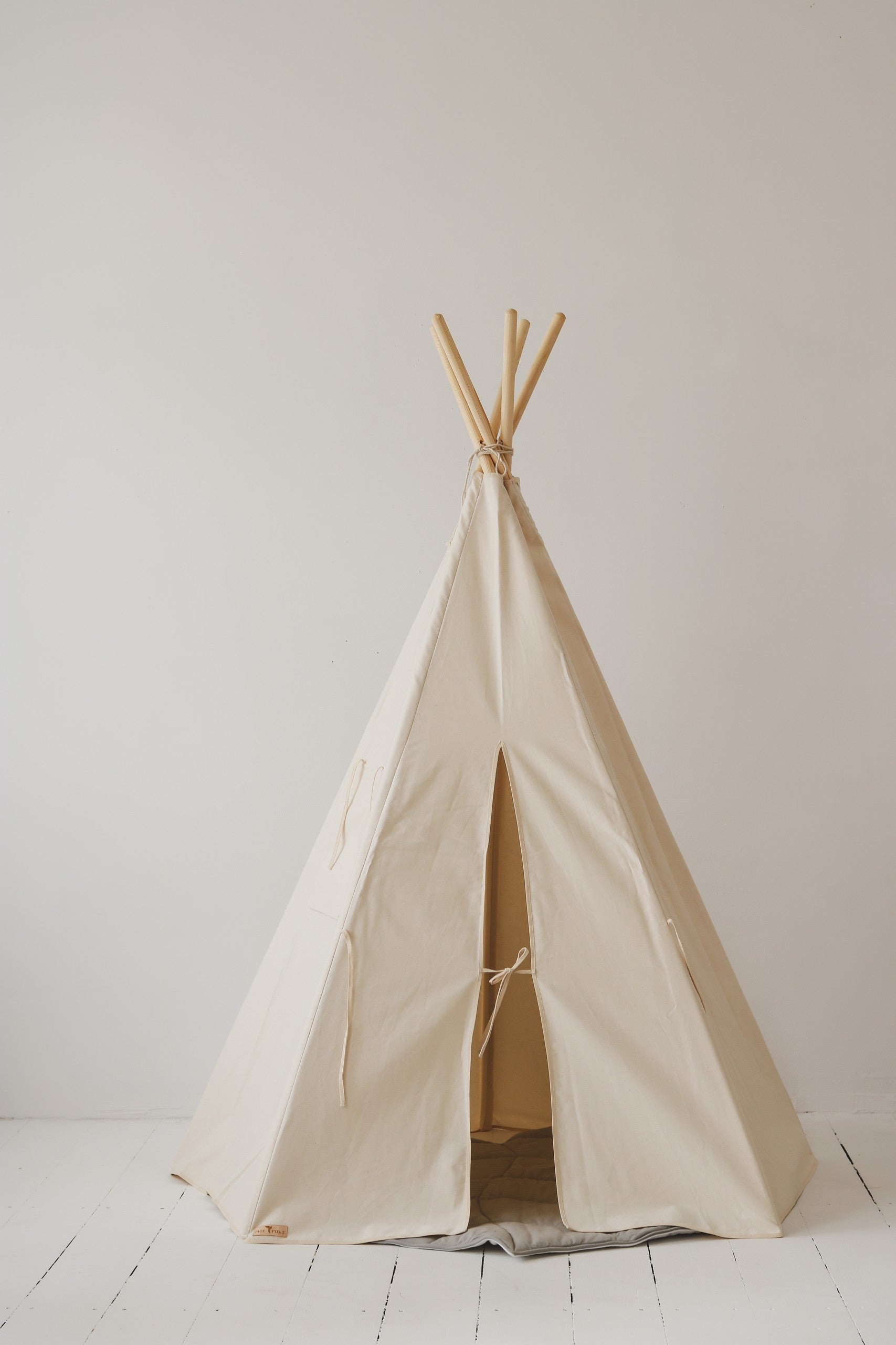 a functional kids teepee tent with pine poles and storage pocket for indoor play