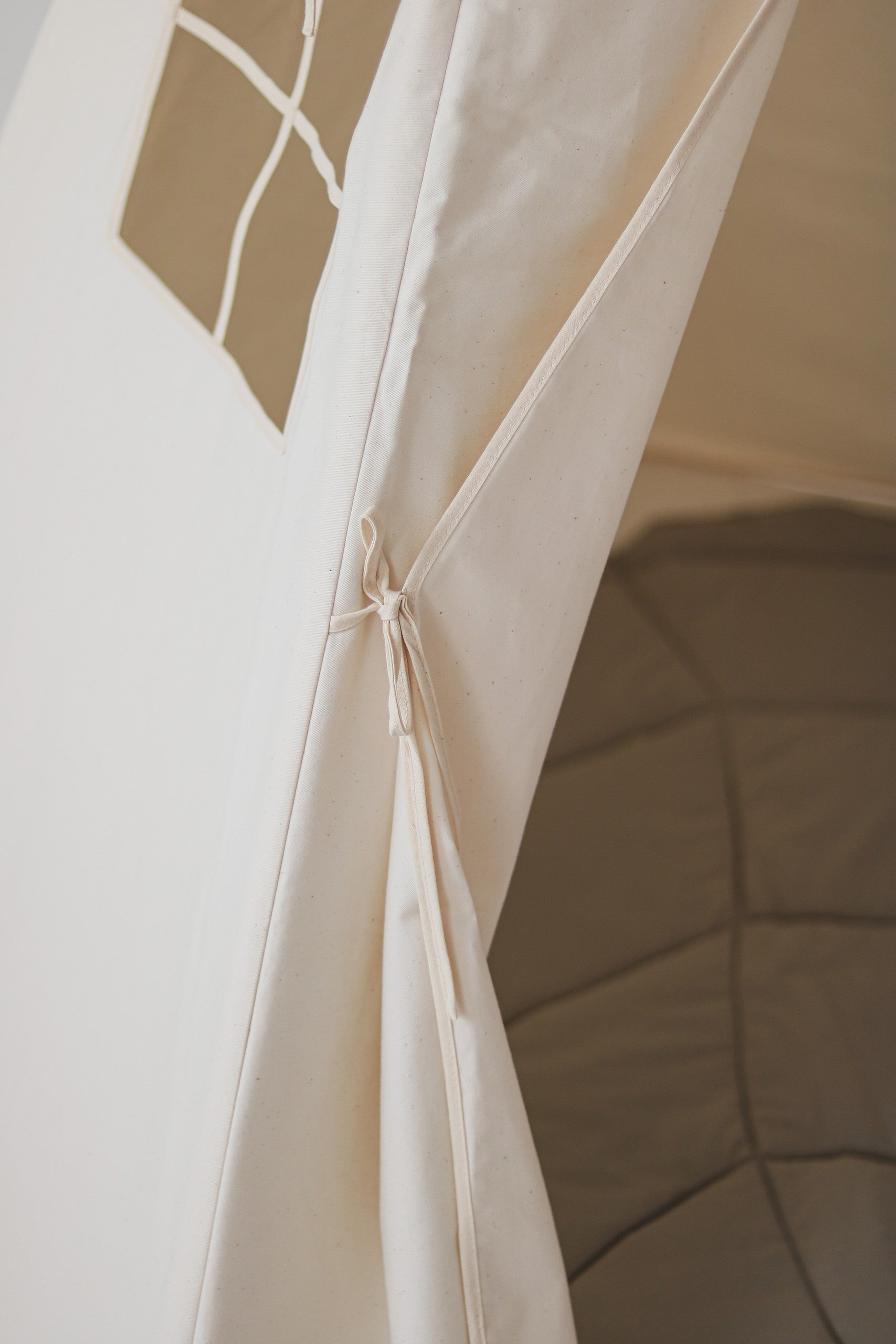 beige kids teepee tent in a cozy indoor corner with soft morning light