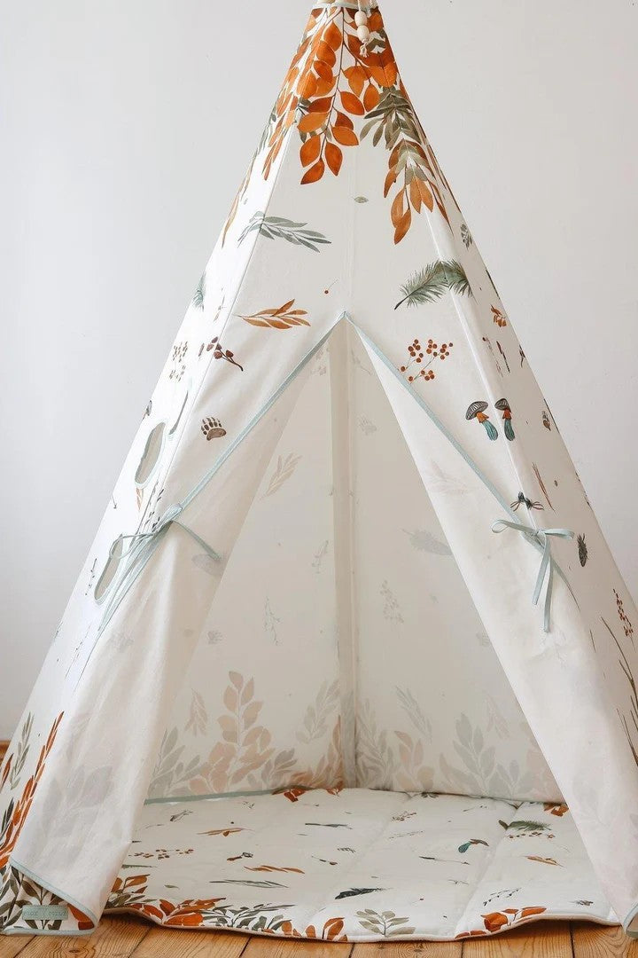a child peeking out from the forest friends teepee tent in a sunlit garden