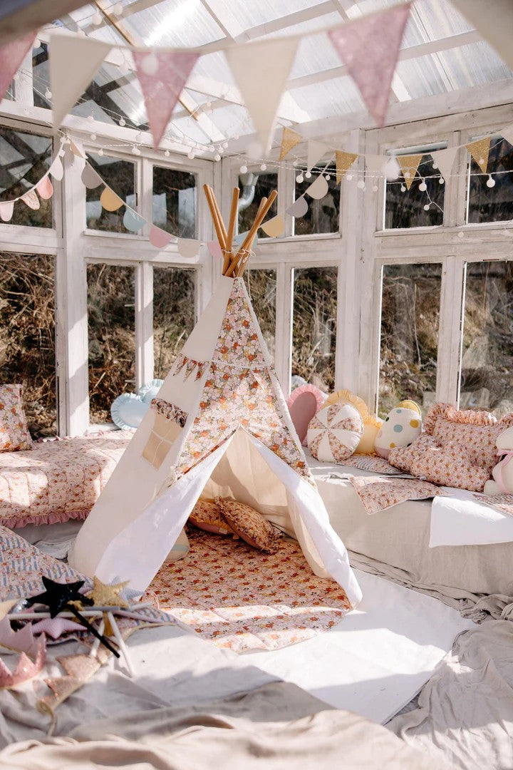 green garden teepee tent with floral print, pine poles, and inner pocket, folded neatly in its cotton storage cover