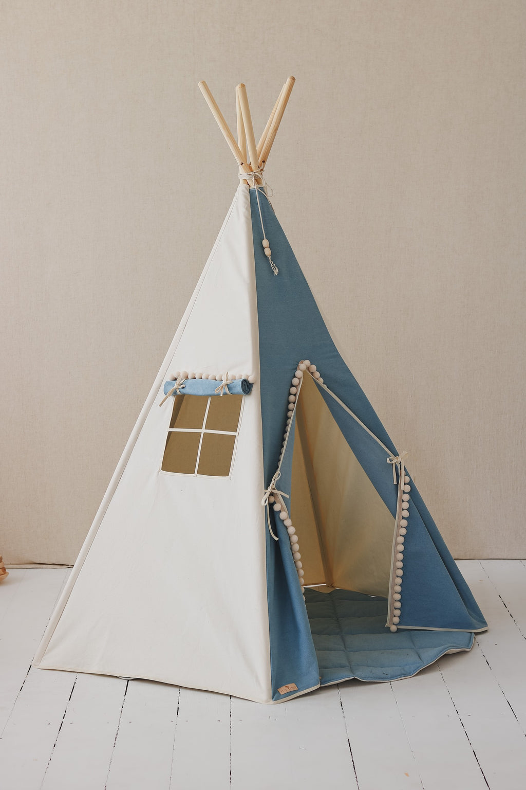 soft cotton teepee tent with pompoms in a cozy, sunlit corner for quiet play
