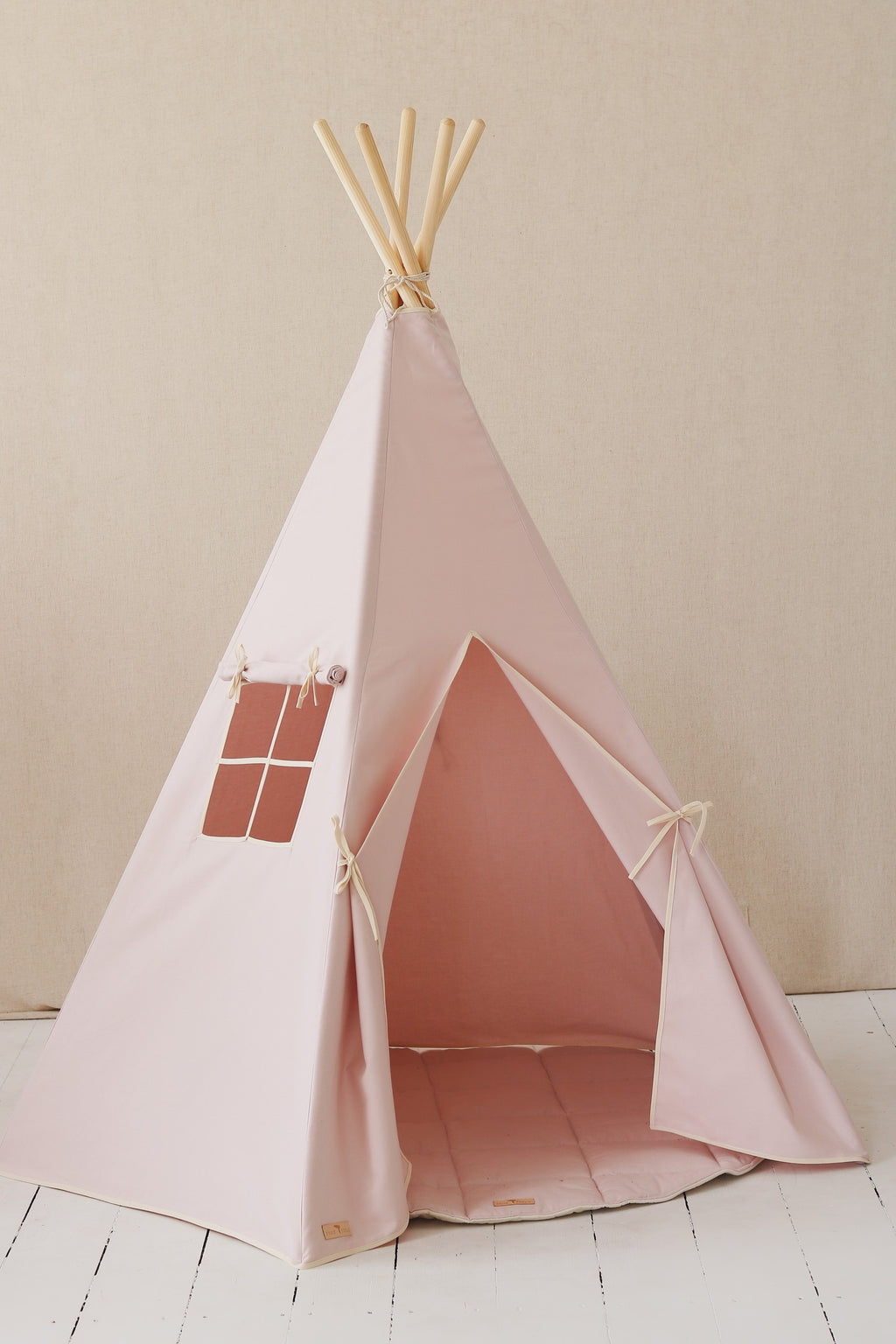 soft pastel pink teepee tent for kids in a cozy indoor corner with gentle morning light