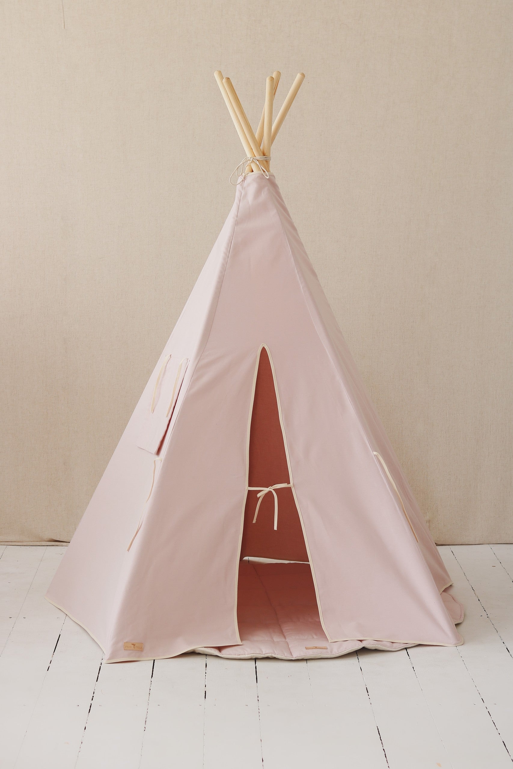 a playful pastel pink kids teepee tent with its door flap tied open, inviting fun indoor adventures