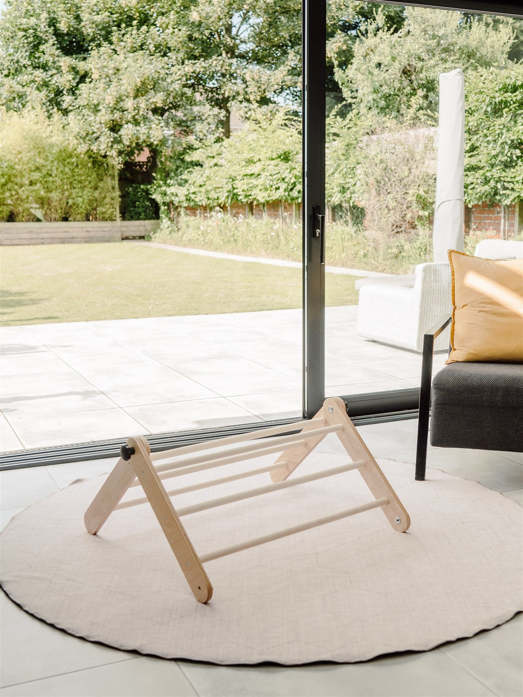 soft-lit birch pikler triangle in a cozy nursery, a comforting space for a toddler's first climb