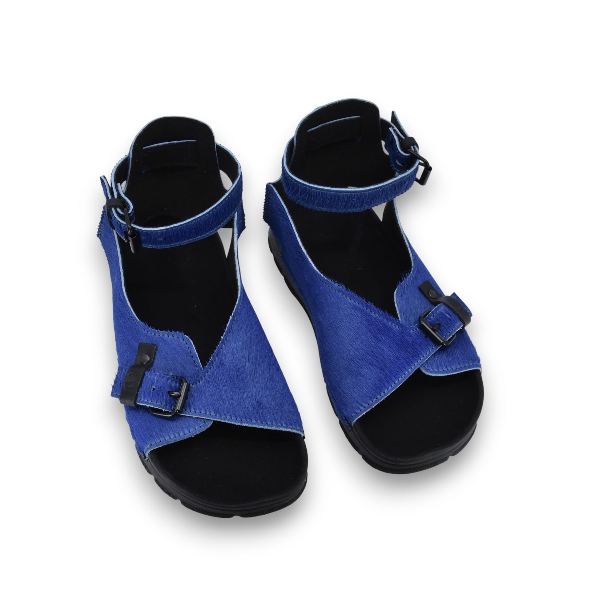 bold blue leather athens sandals on a textured stone path, showcasing confident summer style