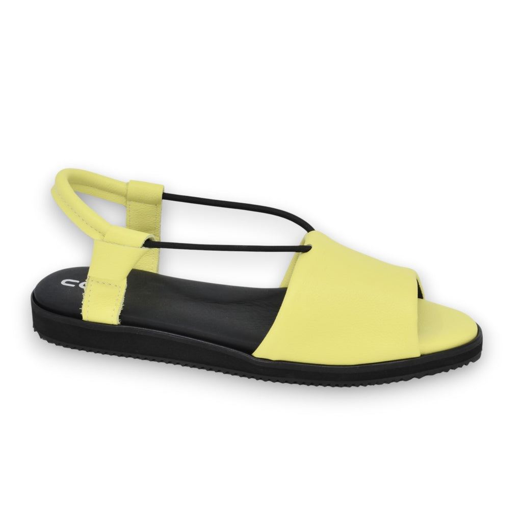 playful close-up of vibrant lime yellow leather sandals on a sunny summer day