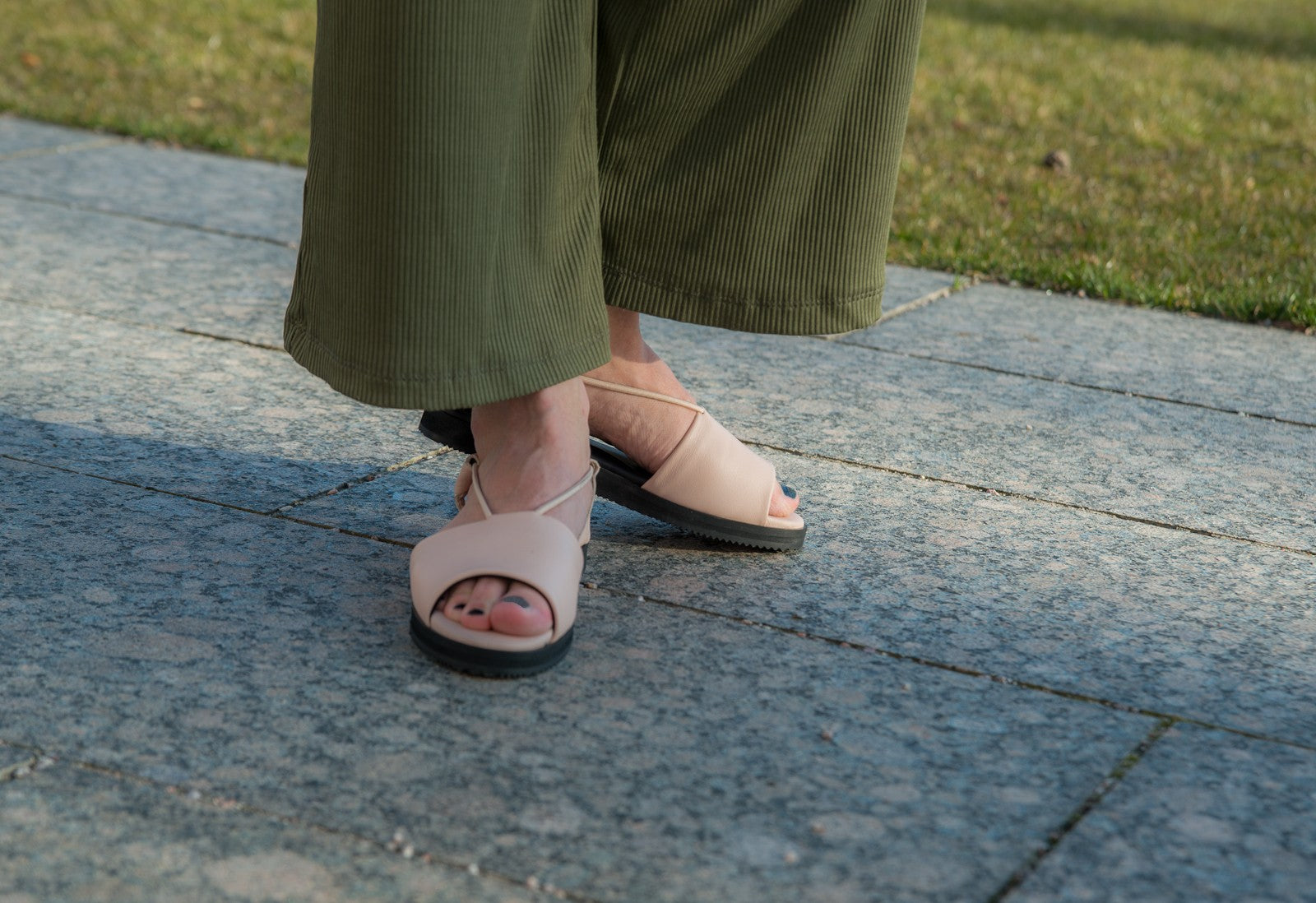 side profile of nude toku berlin sandals on soft fabric, highlighting the elegant leather and gentle lycra lining