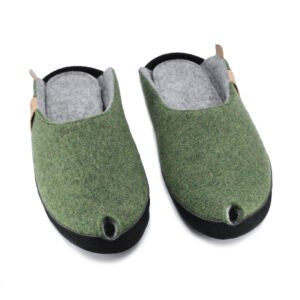 confident close-up of moss green lambswool slippers with a bold black sole