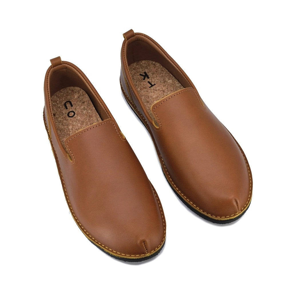 soft ocre leather loafers in warm, inviting light, showcasing their comfortable, handcrafted elegance