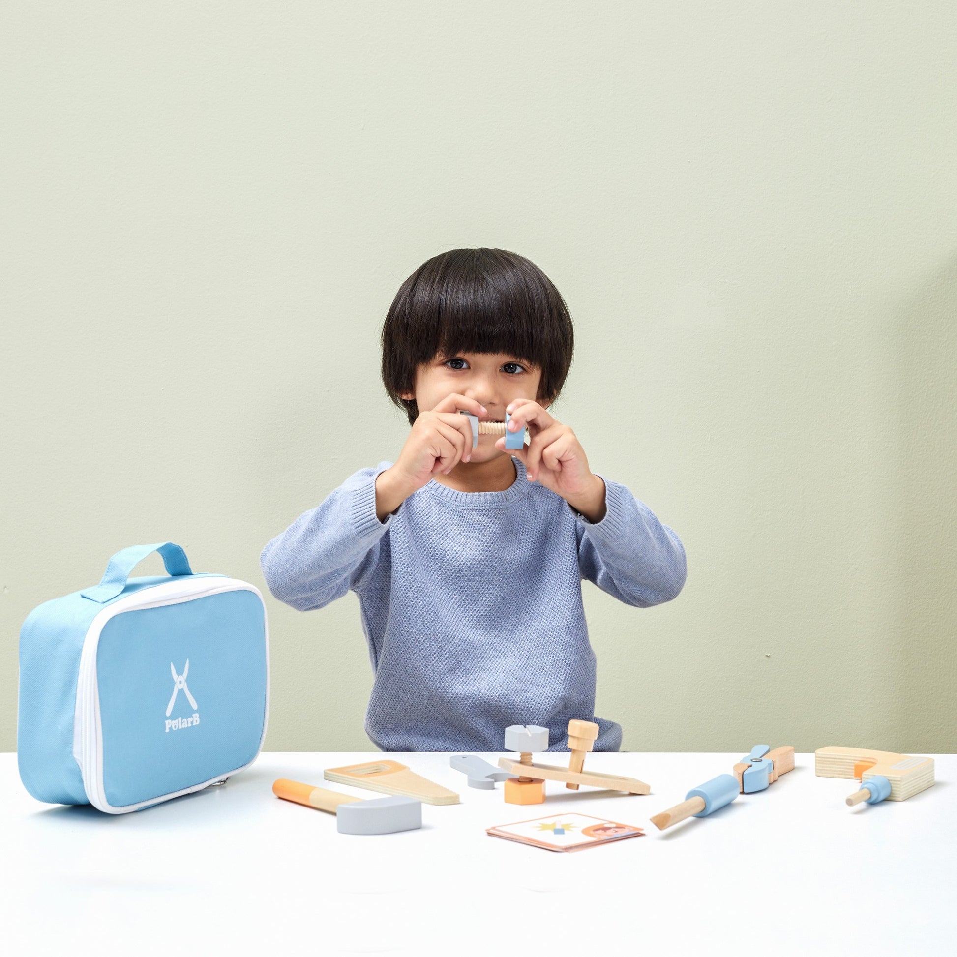 bold little handyman wooden tool bag with pastel tools, open to show hammer and screws