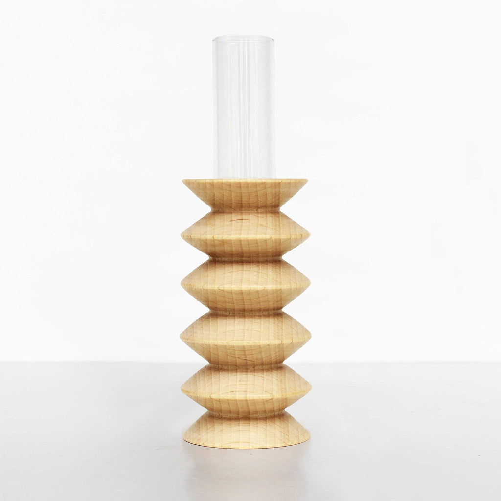 playful beech wood totem vase on a sunlit windowsill with a single cheerful flower