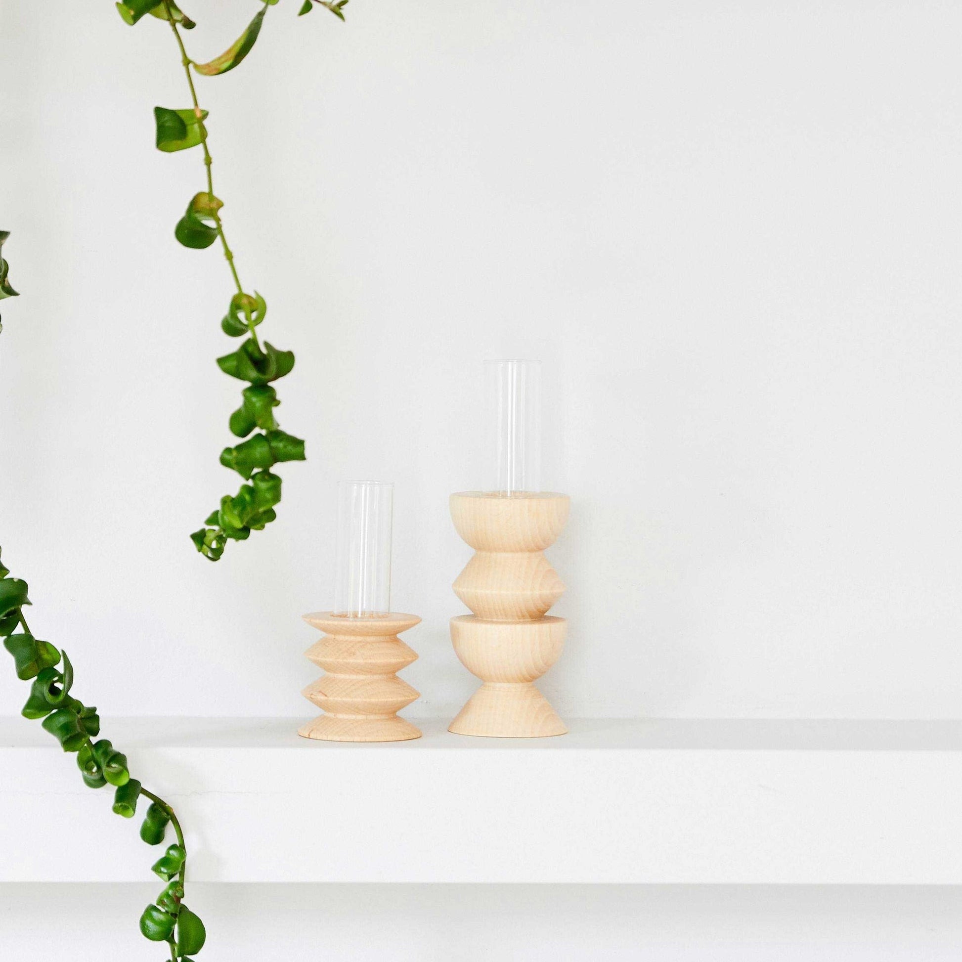 playful medium totem vase with a sunlit wooden base and a clear glass tube on a bright shelf