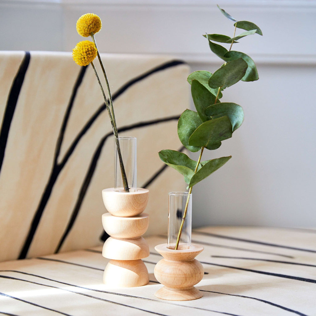 softly lit modern wooden vase with a single stem flower in a cozy living room setting