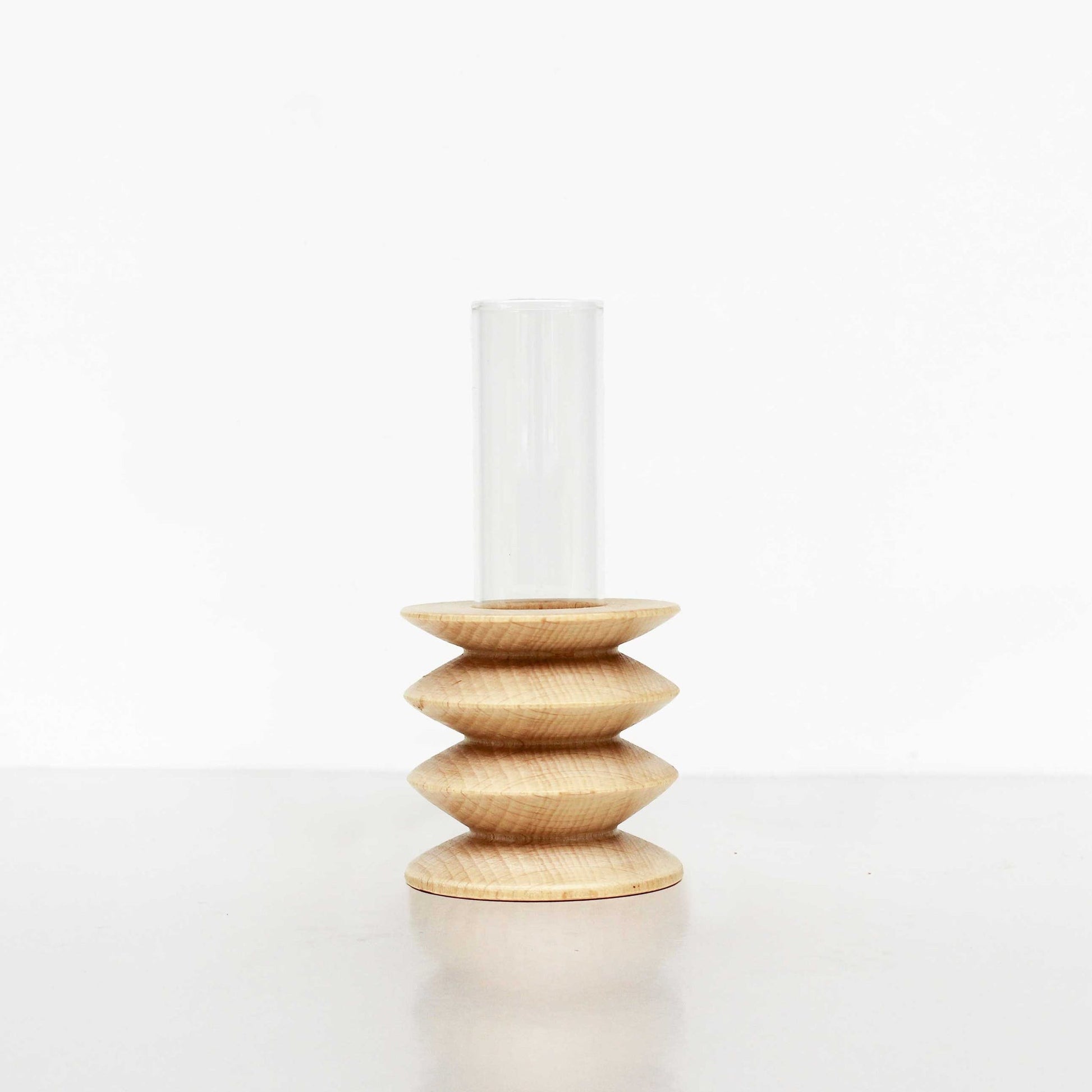 soft-lit short totem wooden vase on a cozy tabletop with a single stem