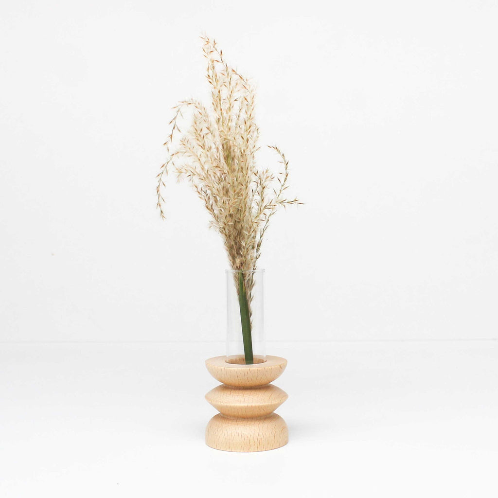 bold statement totem vase in beech wood with glass tube on a dark background