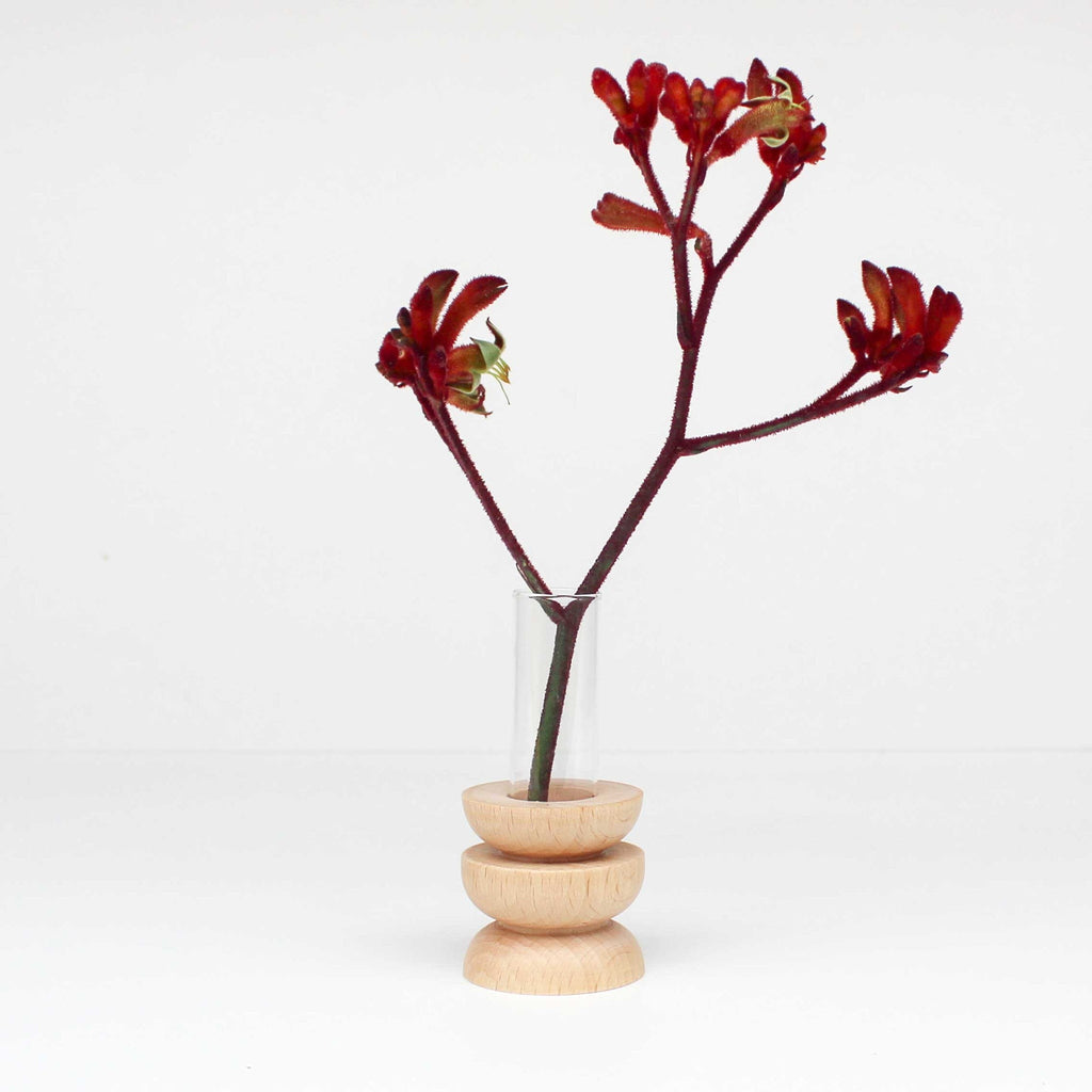 elegant short totem wooden vase with glass tube on a minimalist table