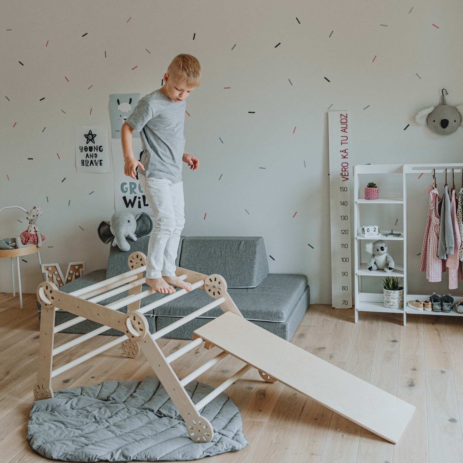a toddler laughing while climbing the montessori ramp in a sunlit playroom