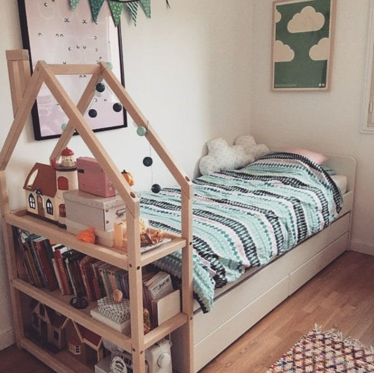 elegant white house-shaped kids shelf with neatly arranged books and toys in a minimalist nursery