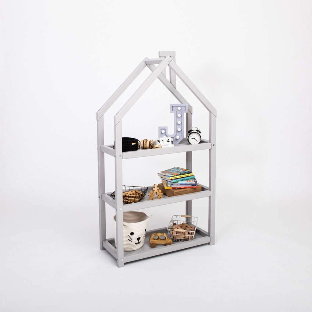 a playful grey house-shaped shelf for kids filled with colorful books and toys