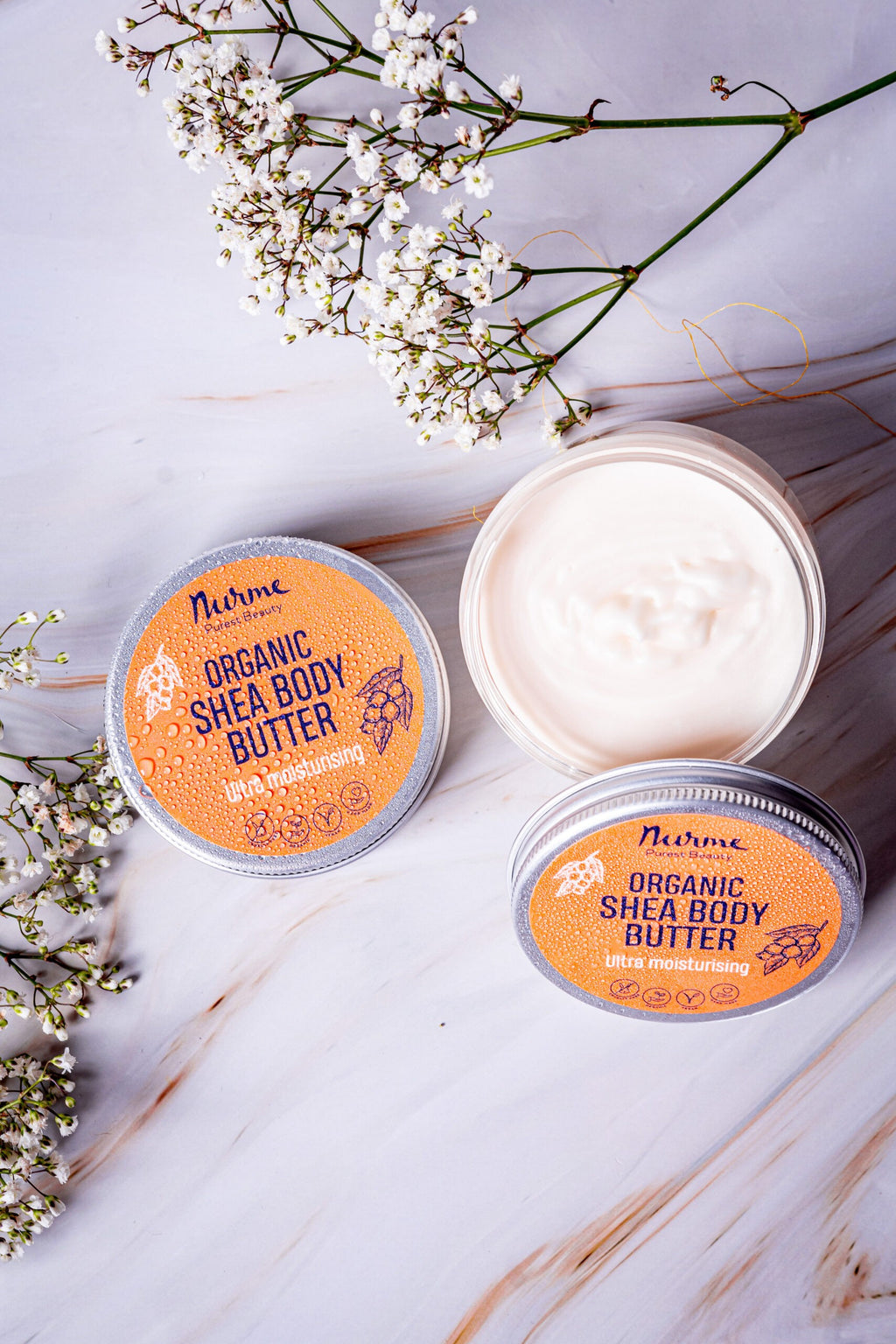 bold close-up of rich shea body butter in hand with golden morning light