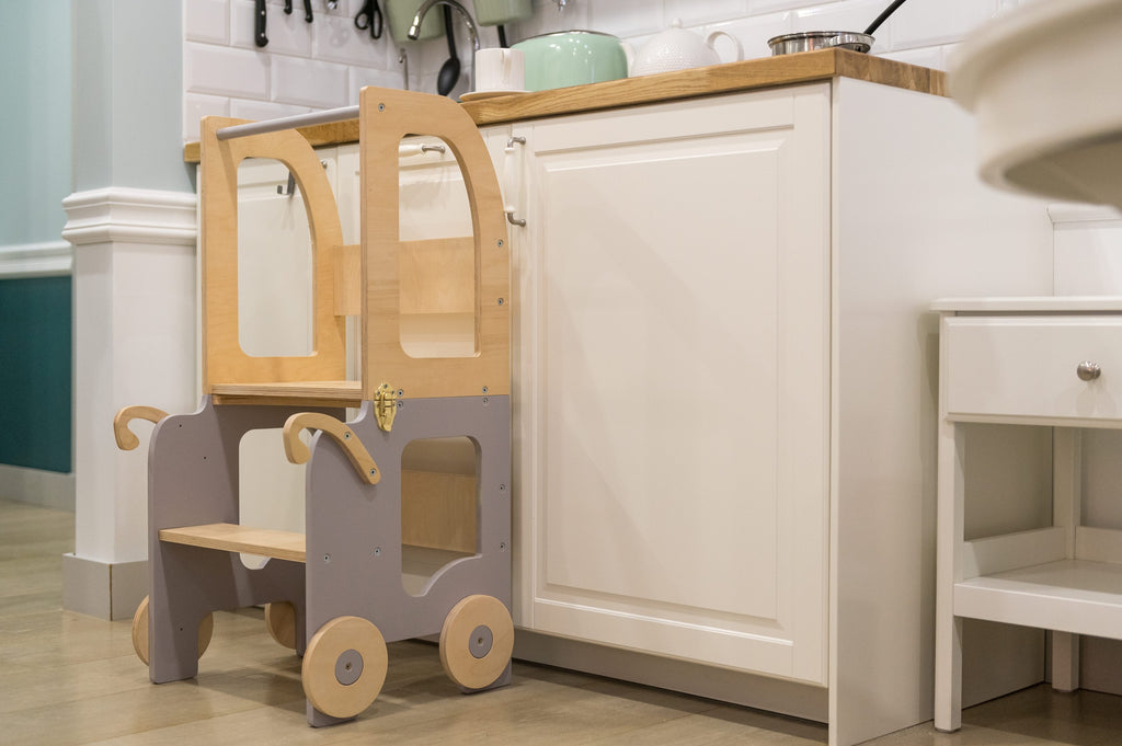 a child in a soft cotton outfit sits at the warm yellow montessori table for a cozy snack