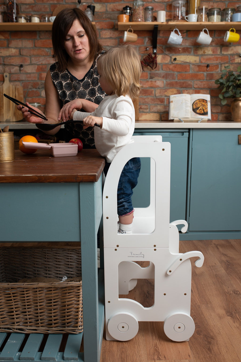 a child in a soft cotton outfit stands at the warm yellow montessori table, bathed in gentle morning light