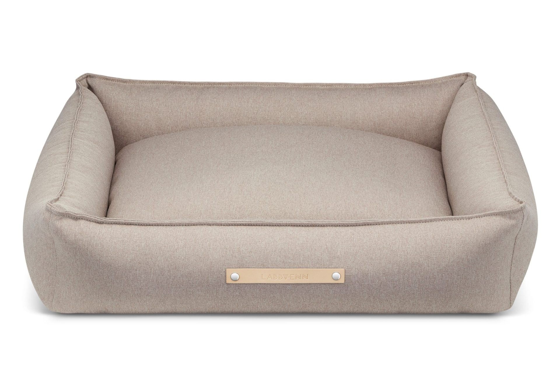 soft nut-brown töve dog bed in a cozy corner, offering a snug and secure retreat for a resting dog