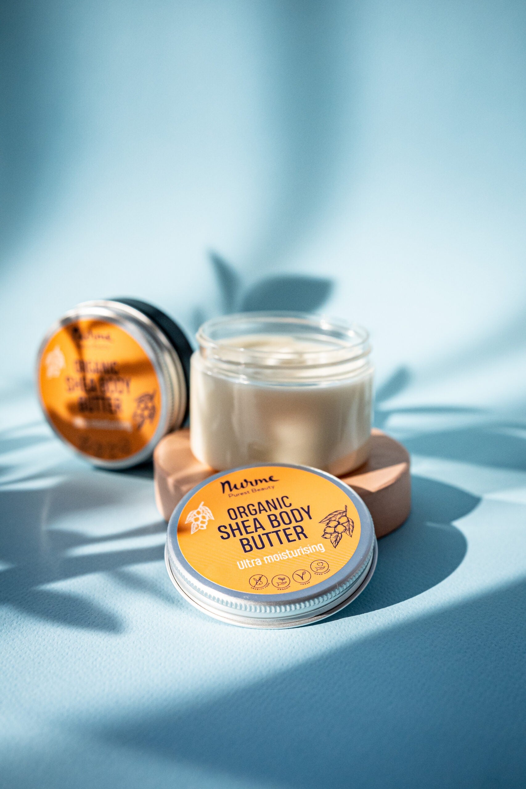 bold close-up of rich shea body butter with a golden glow, ready to deeply moisturize