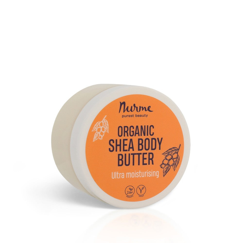 a soft-focus jar of nurme shea body butter with a spoonful of the rich cream